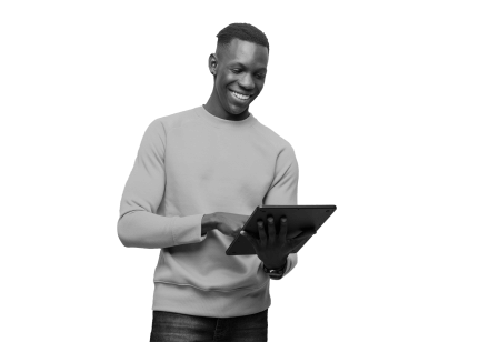  A man smiling looking at a tablet, happy after finding out the key features of a human resource system.