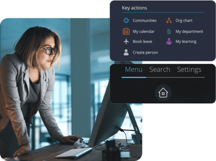 A lady standing over a desktop. with People first's key actions dashboard and menu displaying.